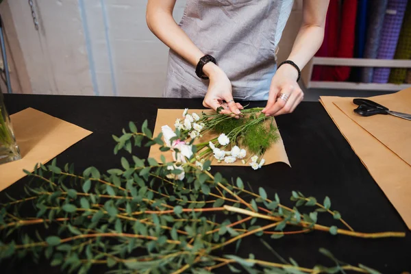 Handen van jonge vrouw bloemist maken boeket met witte bloemen — Stockfoto