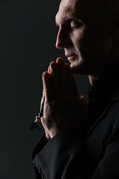 Homem com os olhos fechados segurando rosário e orando — Fotografia de Stock