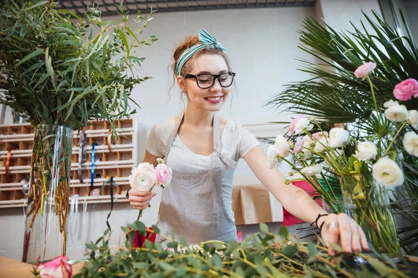 Happy woman florist making bouquet in flower shop — Stock Photo, Image