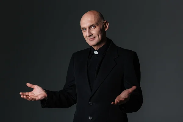 Sacerdote sorrindo de pé e convidando você — Fotografia de Stock