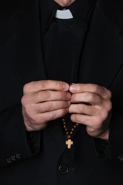 Mãos de padre católico segurando rosário — Fotografia de Stock