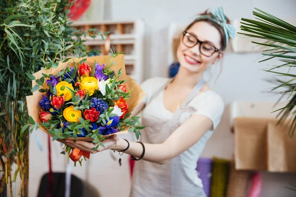 カラフルな花の花束を示す陽気な女性花屋 — ストック写真