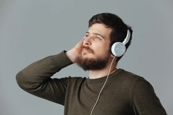 Hombre guapo escuchando música en auriculares — Foto de Stock