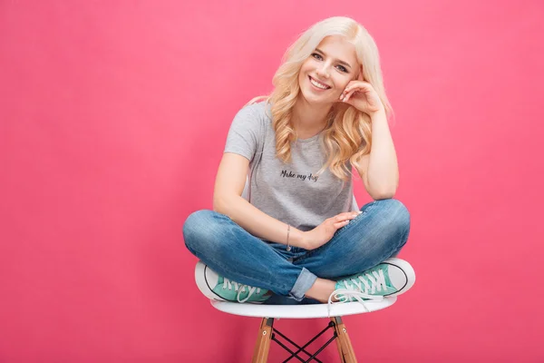 Mujer rubia sonriente sentada en la silla —  Fotos de Stock