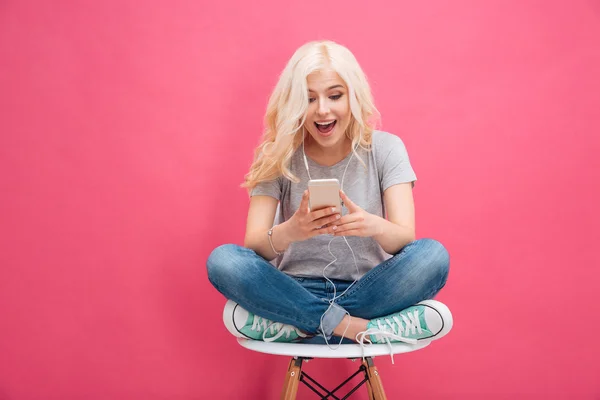 Vrouw met behulp van smartphone met koptelefoon — Stockfoto