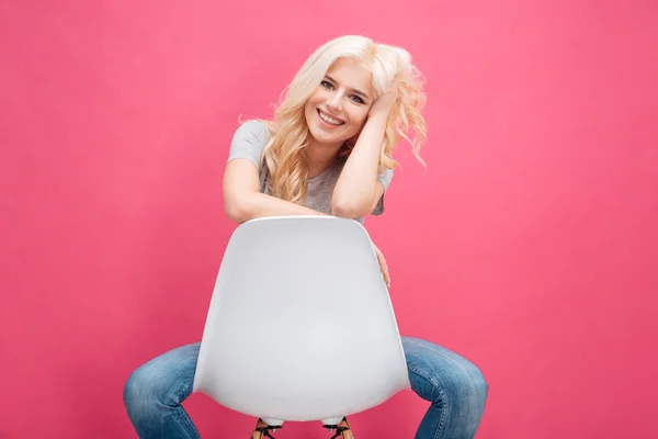 Sorrindo mulher atraente sentada na cadeira — Fotografia de Stock