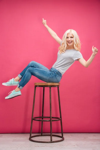 Mulher engraçada alegre sentada na cadeira — Fotografia de Stock