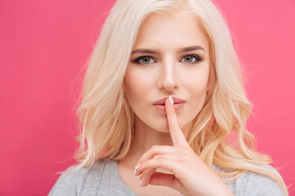 Pretty woman showing finger over lips — Stock Photo, Image