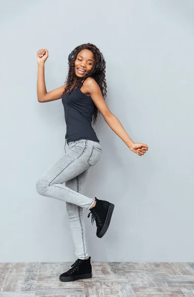 Sorrindo afro-americano mulher posando em fones de ouvido — Fotografia de Stock