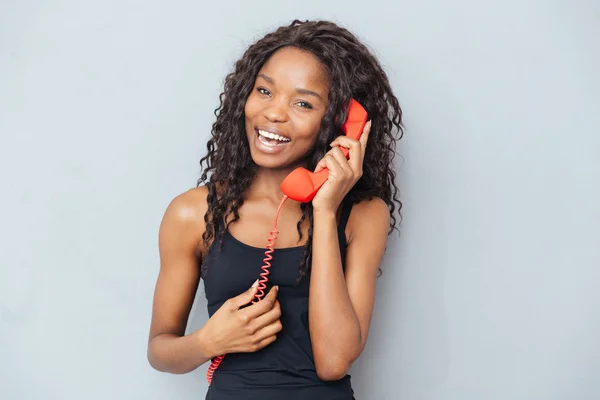 Feliz afro americano mulher falando no retro telefone tubo — Fotografia de Stock