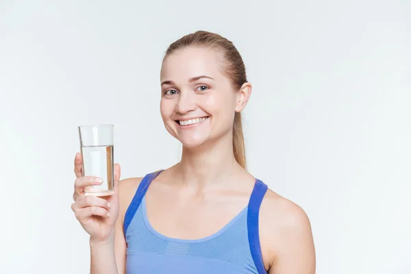 Uśmiechający się fitness kobieta gospodarstwa szkła z wody — Zdjęcie stockowe