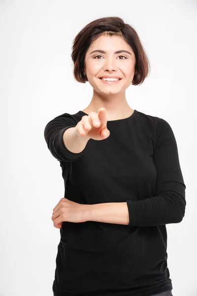Mujer sonriente señalando con el dedo a la cámara — Foto de Stock