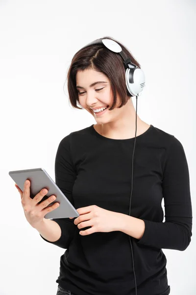 Happy woman using tablet computer with headphones — Stock Photo, Image