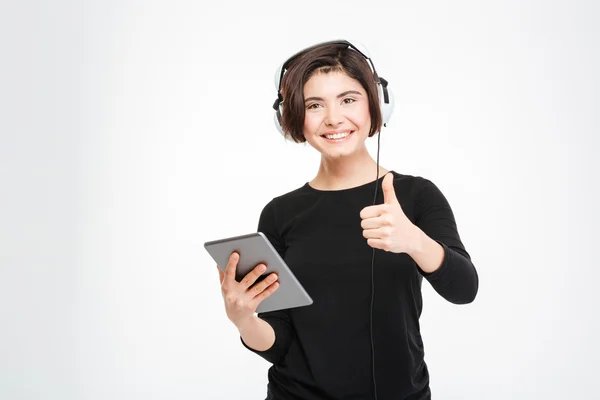 Leende kvinna håller tablet PC och visar tummen — Stockfoto