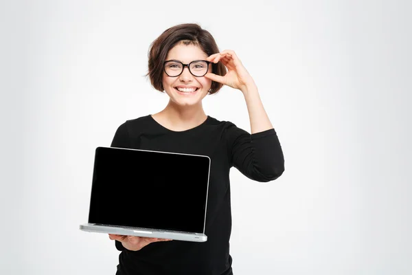 Mulher sorridente mostrando tela do computador portátil em branco — Fotografia de Stock