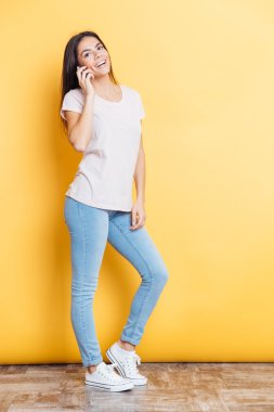 Gülümseyen kadın telefonda konuşuyor.