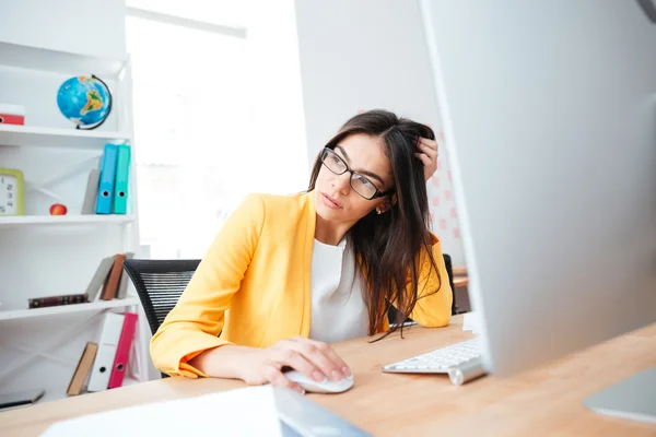 Empresária sentada à mesa com computador no escritório — Fotografia de Stock