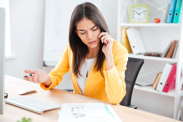 Бізнес-леді розмовляє по телефону в офісі — стокове фото