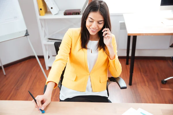 Бізнес-леді розмовляє по телефону в офісі — стокове фото