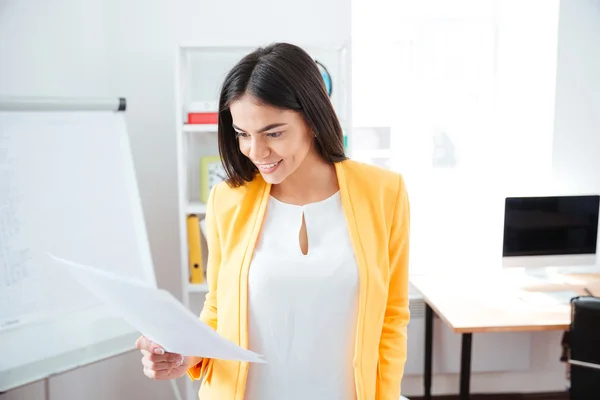 Businesswoman reading paper in office — Stock Photo, Image