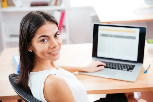 Femme d'affaires assise à la table avec ordinateur portable au bureau — Photo