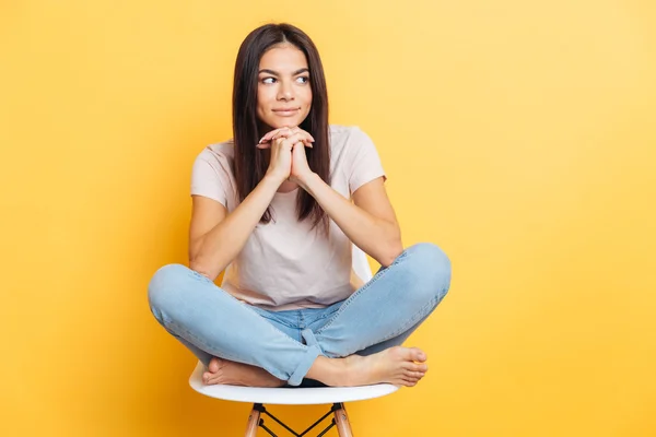 Happy woman sitting on the chair and looking away — Stock Photo, Image