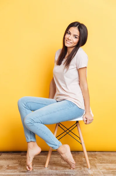 Uśmiechający się ładny kobieta siedzi na krześle — Zdjęcie stockowe