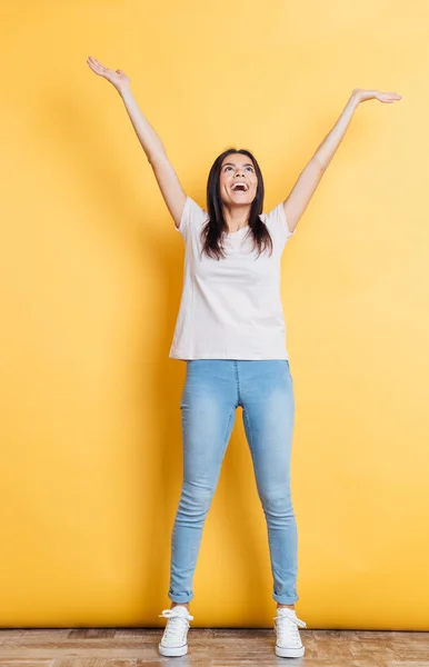 Femme joyeuse debout avec les mains levées — Photo