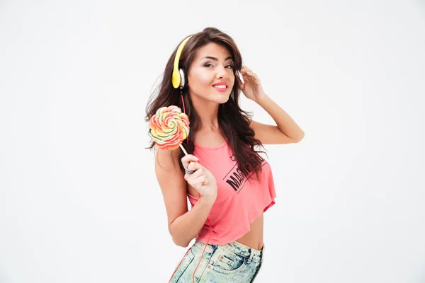 Mujer sonriente en auriculares con piruleta — Foto de Stock