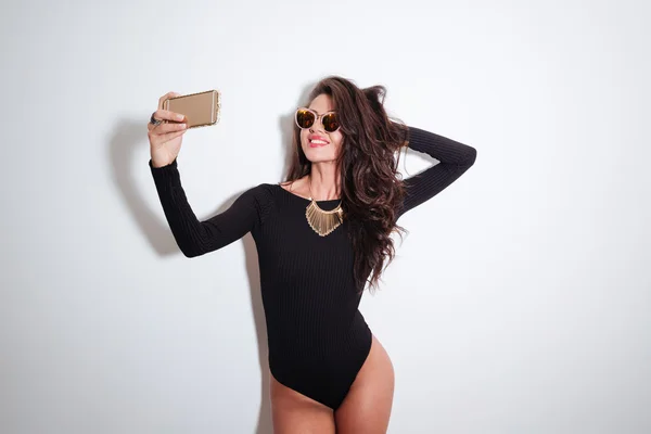 Mulher sorridente em bodysuit fazendo foto selfie — Fotografia de Stock