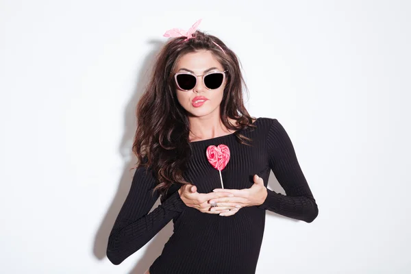 Charming stylish woman holding lollipop between tits — Stock Photo, Image