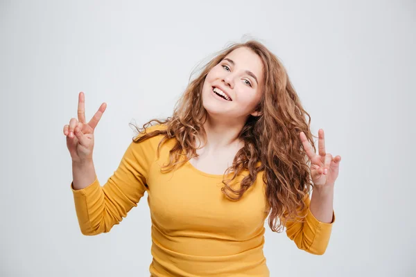 Усміхнена жінка, що показує знак двох пальців — стокове фото