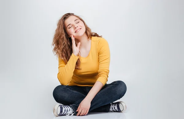 Vrouw zittend op de vloer met gesloten ogen — Stockfoto