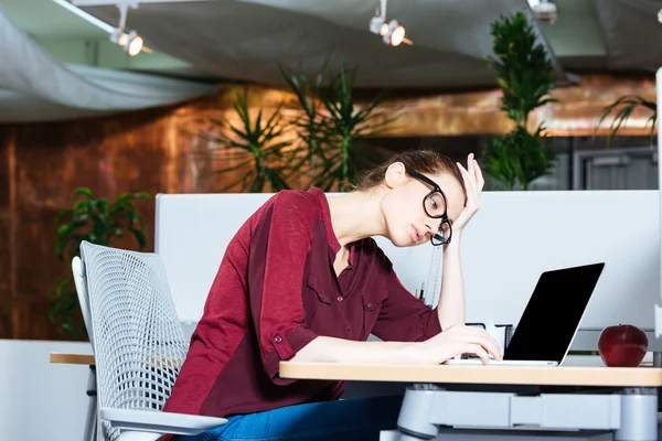 Geschäftsfrau arbeitet mit Laptop und hat Kopfschmerzen im Büro — Stockfoto