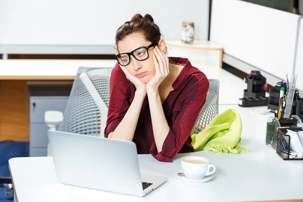 Mujer de negocios agotado trabajando con el ordenador portátil y beber café en la oficina — Foto de Stock