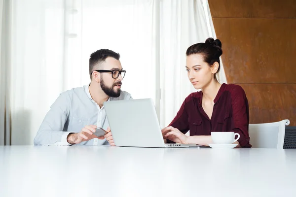 Zwei konzentrierte Geschäftsleute, die mit Laptop im Besprechungsraum arbeiten — Stockfoto