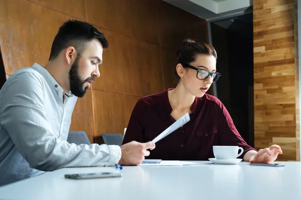 Zwei konzentrierte Geschäftsleute diskutieren Projekt im Besprechungsraum — Stockfoto