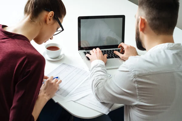 Vue arrière de deux hommes d'affaires sérieux concentrés utilisant un ordinateur portable — Photo