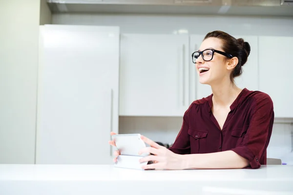 Donna allegra in bicchieri ridere e utilizzando tablet in cucina — Foto Stock