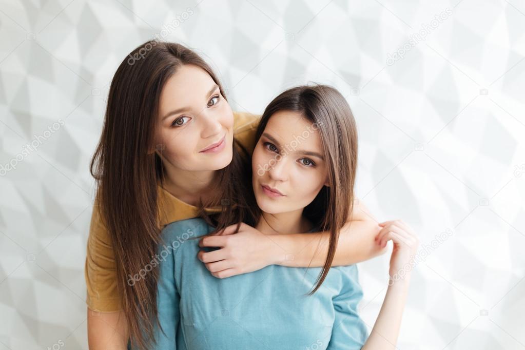 Meninas Lindas Duas Irmãs Gêmeas Sentadas E Posando No Estúdio Com Fundo  Branco Imagem de Stock - Imagem de profissional, humano: 165767723