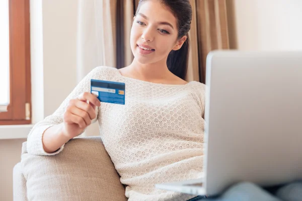 Mulher com computador portátil e cartão de crédito — Fotografia de Stock