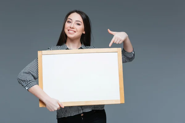 Businesswoman pointing finger on blank board — Stock Photo, Image