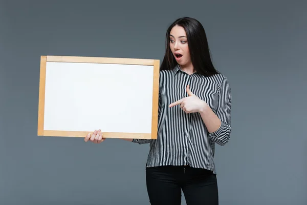 Young businesswoman holding blank board — Stock Photo, Image