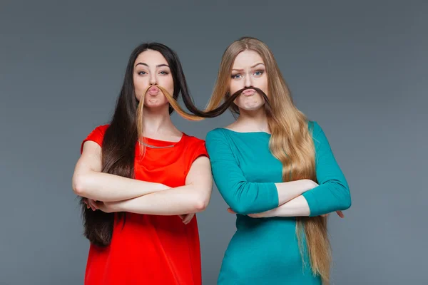 Namoradas engraçadas fazendo bigode com seu cabelo — Fotografia de Stock