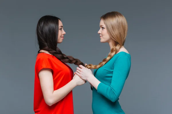 Dos mujeres sonrientes cogidas de la mano y mirándose —  Fotos de Stock