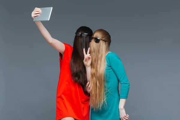 Två komiska kvinnor med ansikten täckta av hår med selfie — Stockfoto