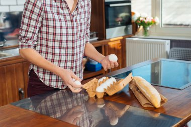 Genç kadın mutfağa yemek kahvaltı için yumurta kullanılarak