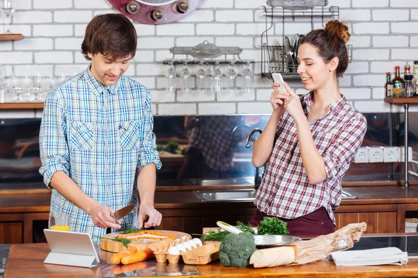 Lachende vrouw nemen van foto's van haar man op de keuken — Stockfoto