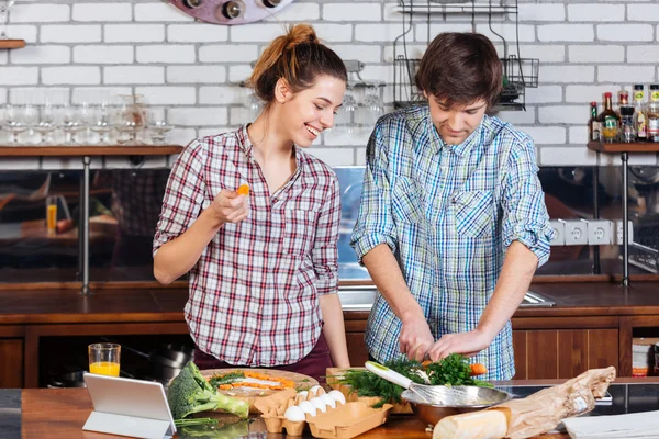 Hermosa pareja de pie y cocinar juntos en la cocina — Foto de Stock