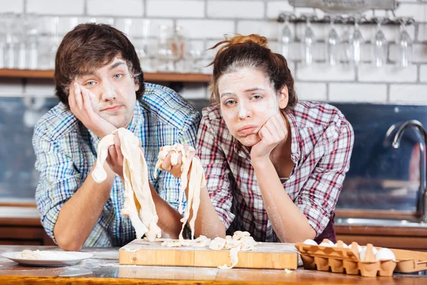 Zmęczony para z mąki na twarzach wyrabiania ciasta w kuchni — Zdjęcie stockowe